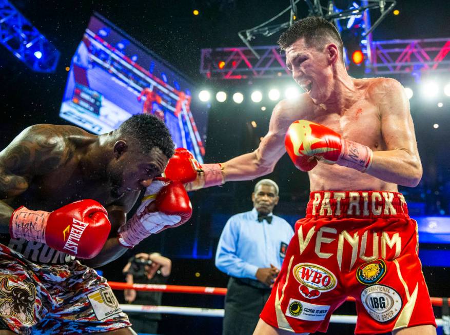 Carlos Adames, left, takes a punch from Patrick Teixeira during round 11 in their super welterw ...