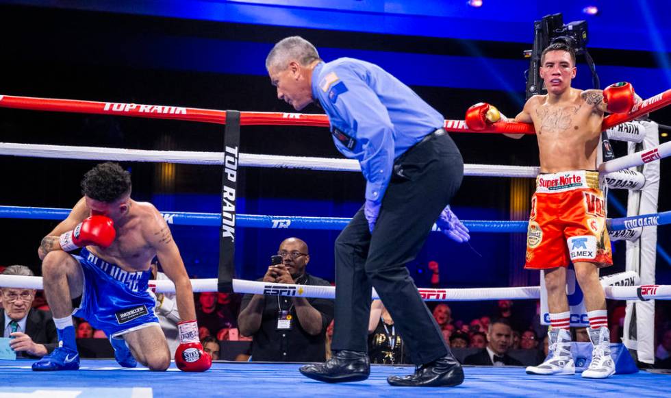 Adam Lopez, left, is checked on by the referee as Oscar Valdez waits in the corner during a kno ...