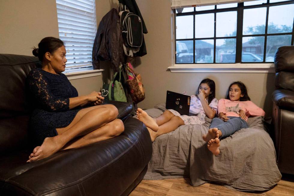 Margarita DeLoach, 45, talks to her daughters Maura Castro, 10, center, and Mililani Castro, 12 ...