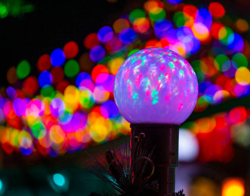 An illuminated globe as part of the holiday lights display in the yard of Maria Acosta and Juan ...