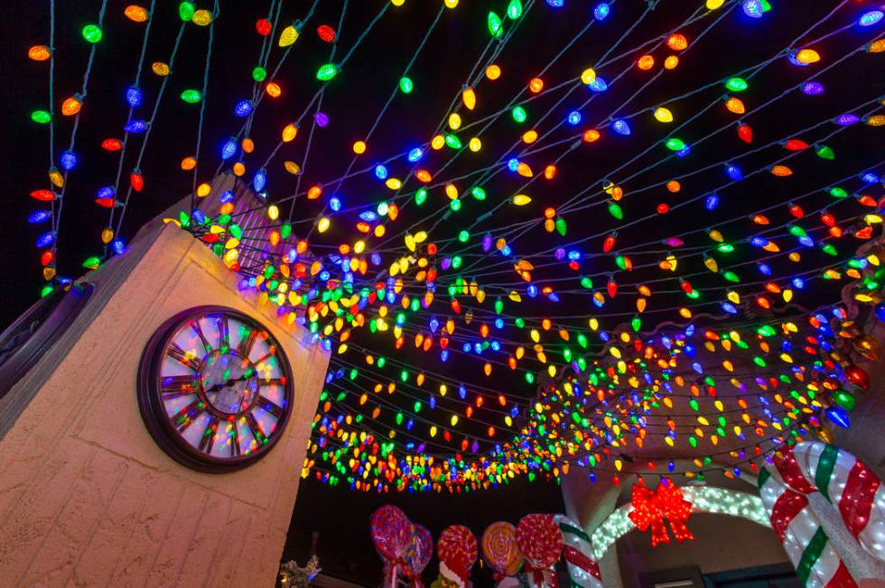 A clock tower and strings of lights as part of the holiday lights display in the yard of Maria ...