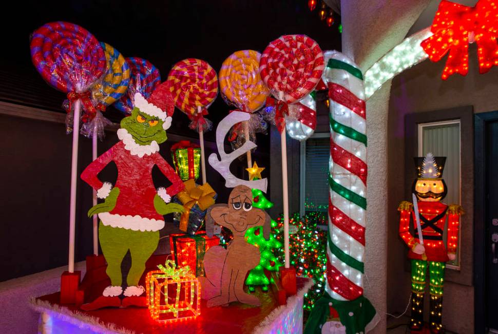 The Grinch Who Stole Christmas is part of the holiday lights display in the yard of Maria Acost ...