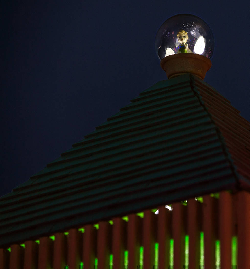 Tinkerbell sits atop a clock tower as part of the holiday lights display in the yard of Maria A ...