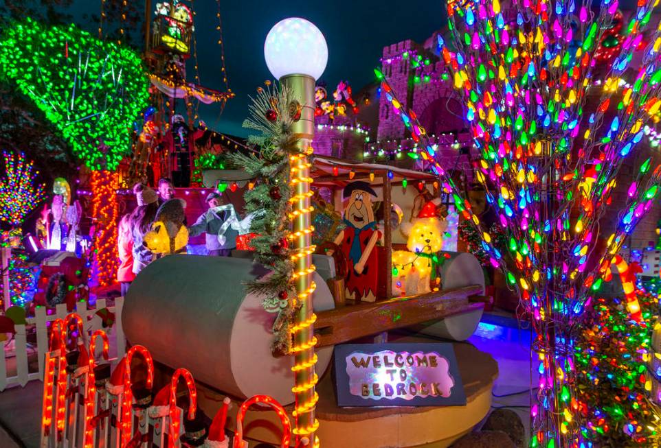 Fred Flintstone in his car is apart of the holiday lights display in the yard of Maria Acosta a ...