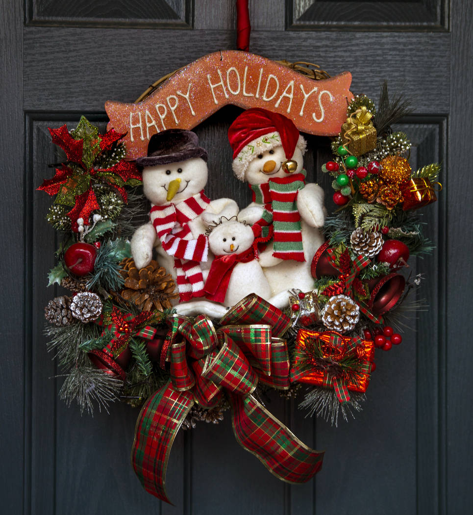 The wreath on the front door is the first item ever hung for the holiday lights display in the ...