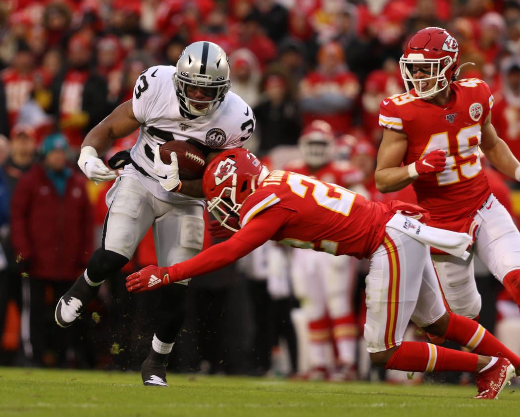 Oakland Raiders running back DeAndre Washington (33) is tackled by Kansas City Chiefs free safe ...