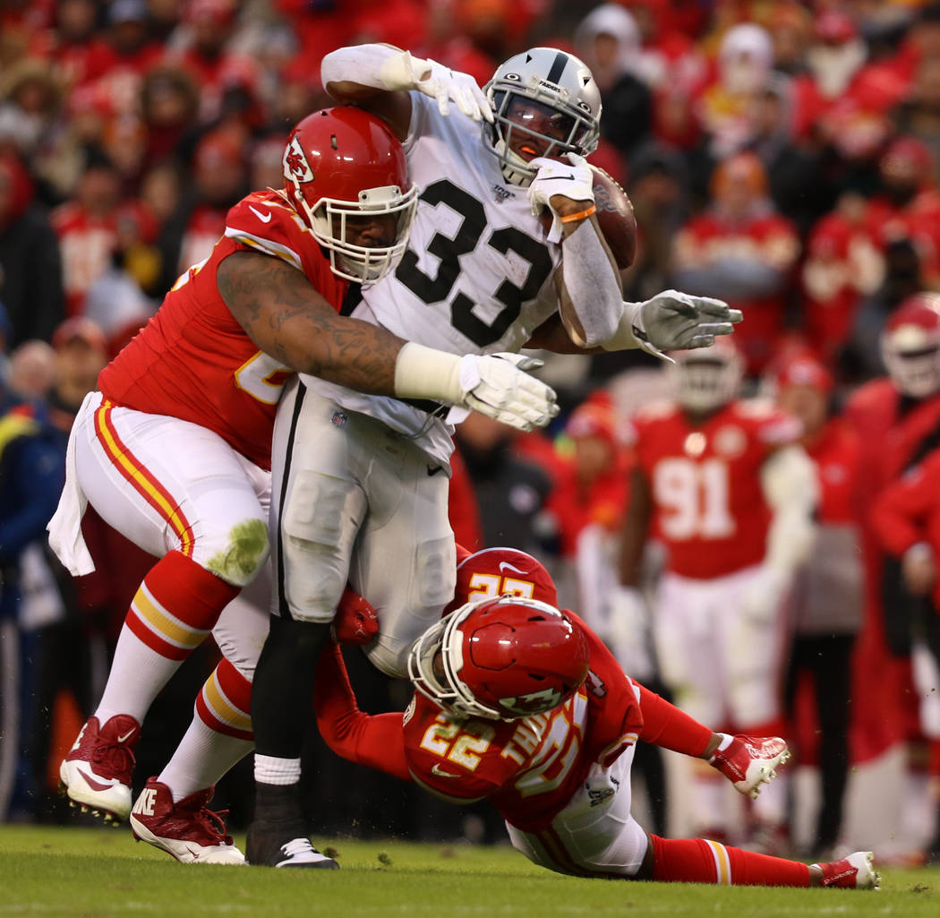Oakland Raiders running back DeAndre Washington (33) fights for yards as Kansas City Chiefs fre ...