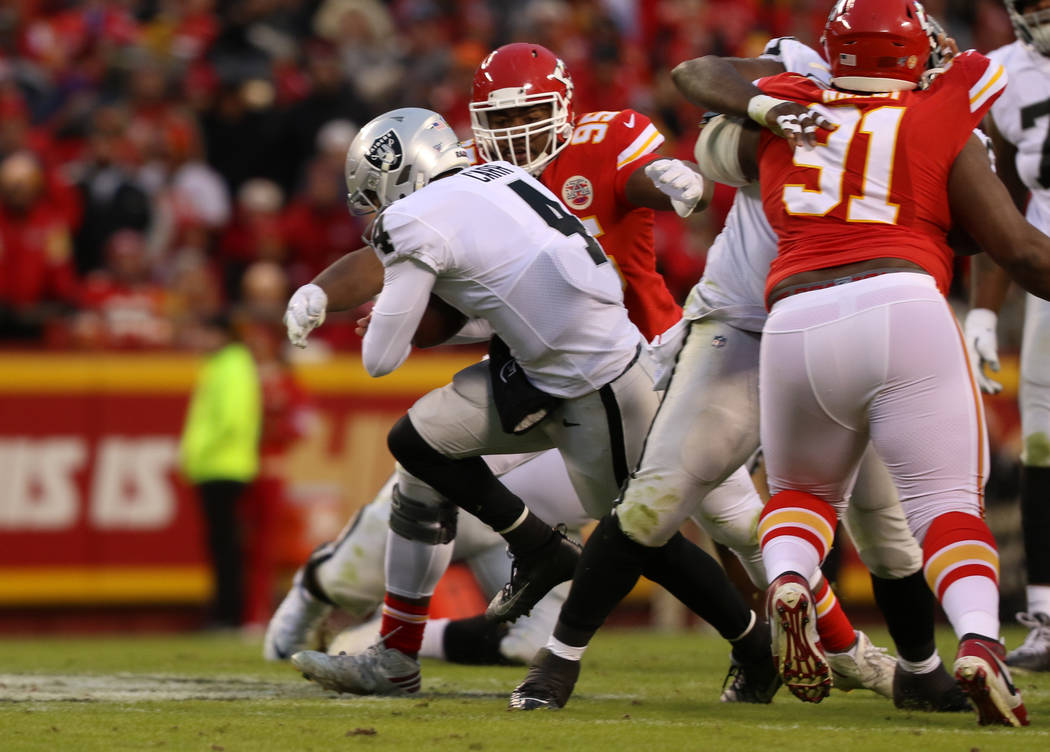 Oakland Raiders quarterback Derek Carr (4) scrambles with the football as Kansas City Chiefs de ...