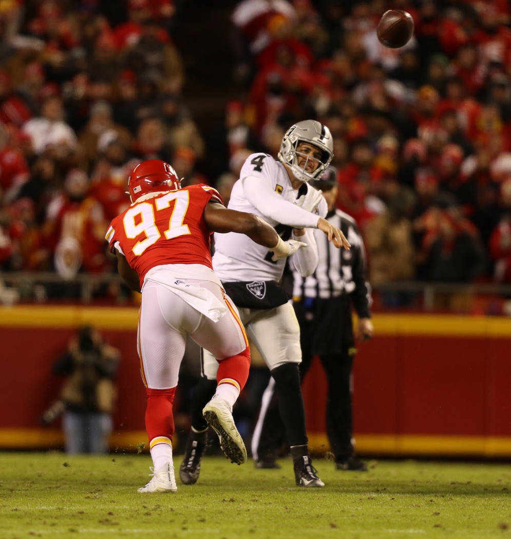 Oakland Raiders quarterback Derek Carr (4) throws the football as he is pressured by Kansas Cit ...