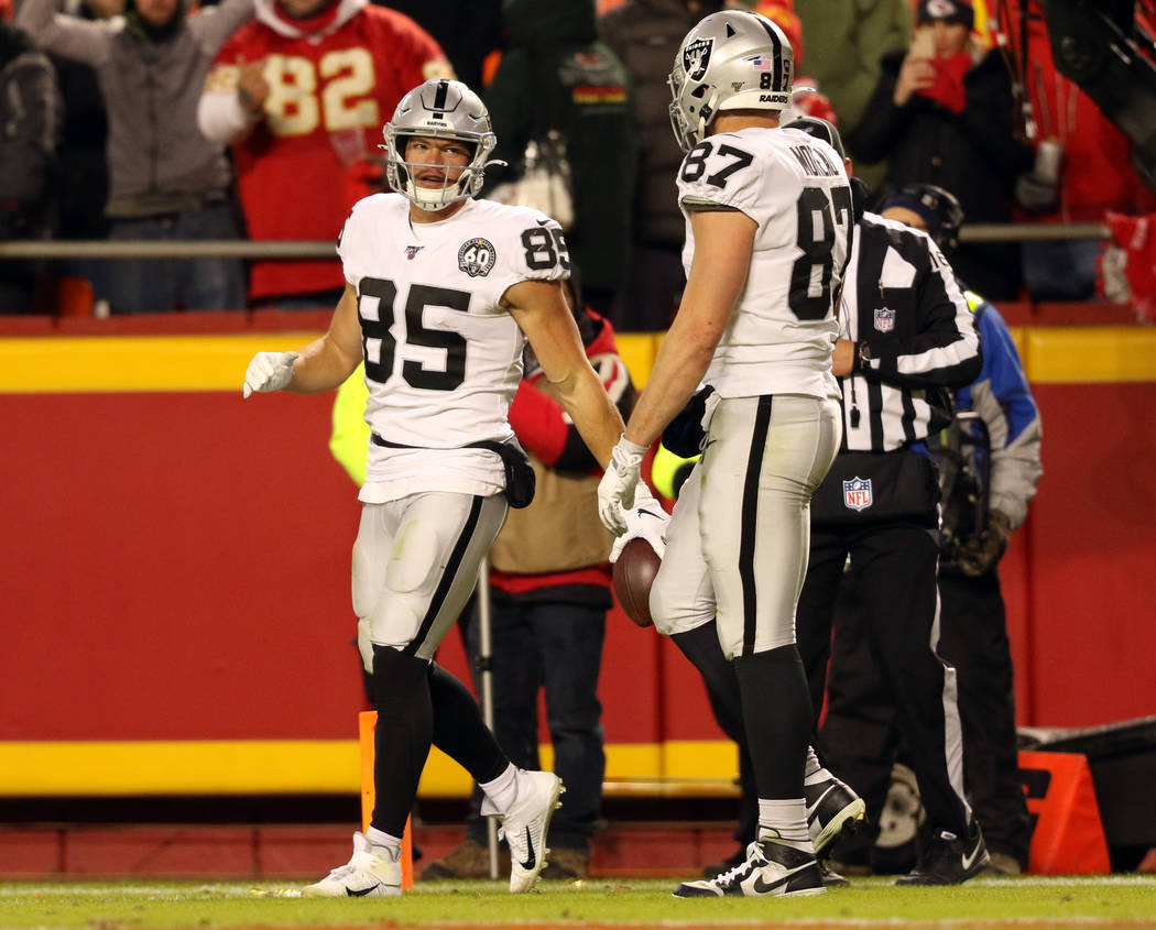 Oakland Raiders tight end Derek Carrier (85) holds on to the football as tight end Foster Morea ...