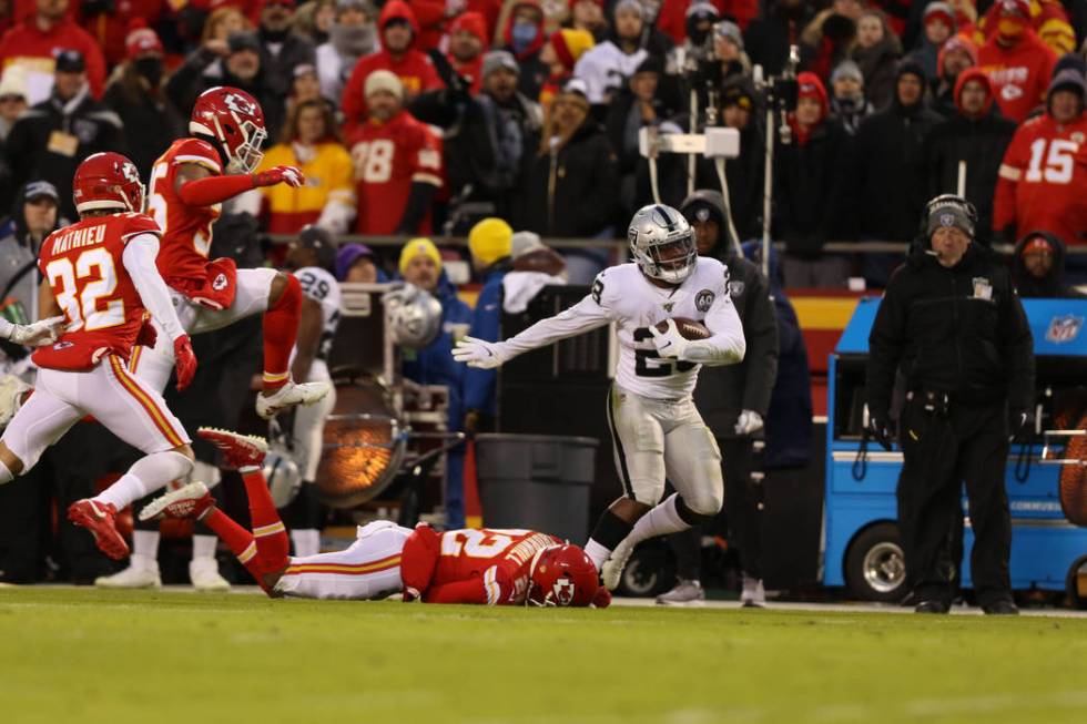 Oakland Raiders running back Josh Jacobs (28) fights for yards as Kansas City Chiefs free safet ...