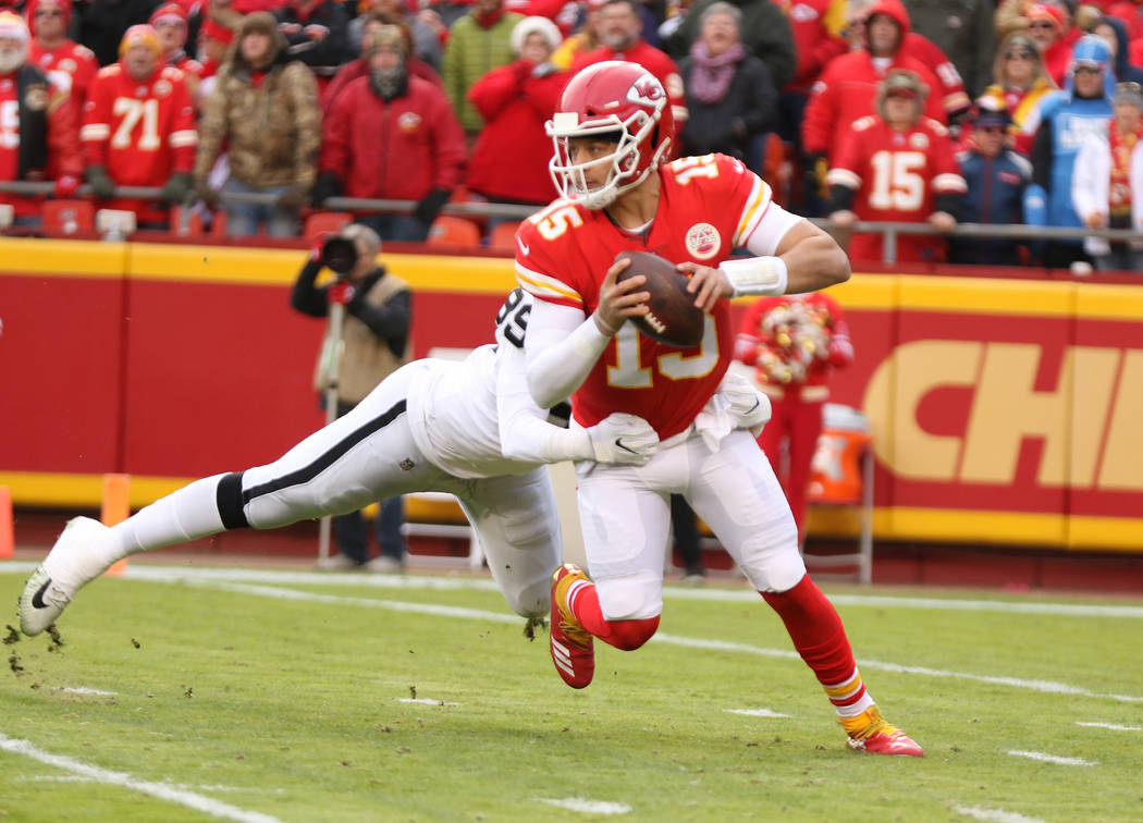 Kansas City Chiefs quarterback Patrick Mahomes (15) sheds a tackle by Oakland Raiders defensive ...