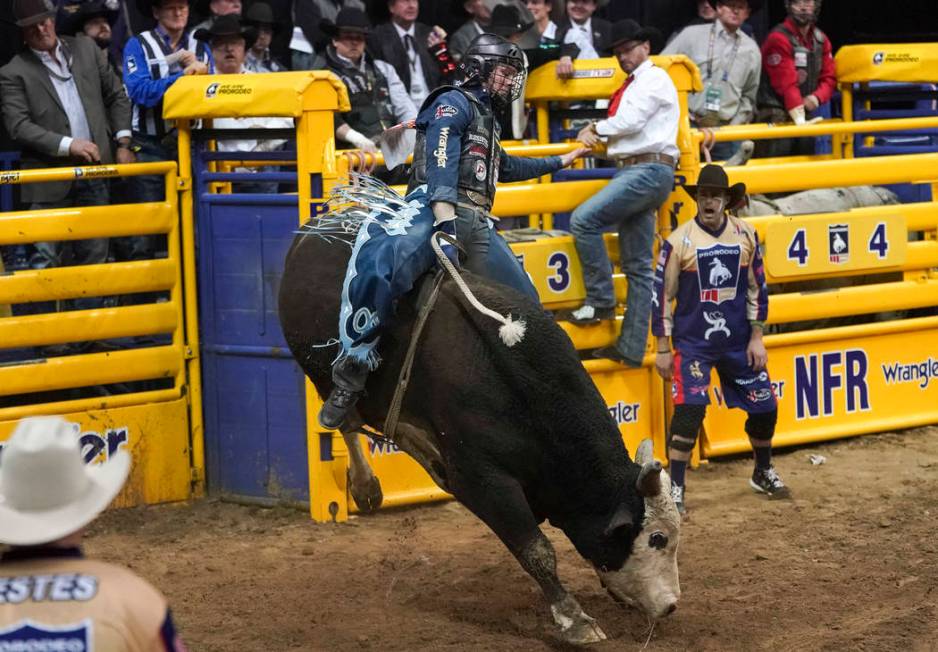 Joe Frost of Randlett, Utah (103) competes in the bull riding event during the eighth go-round ...