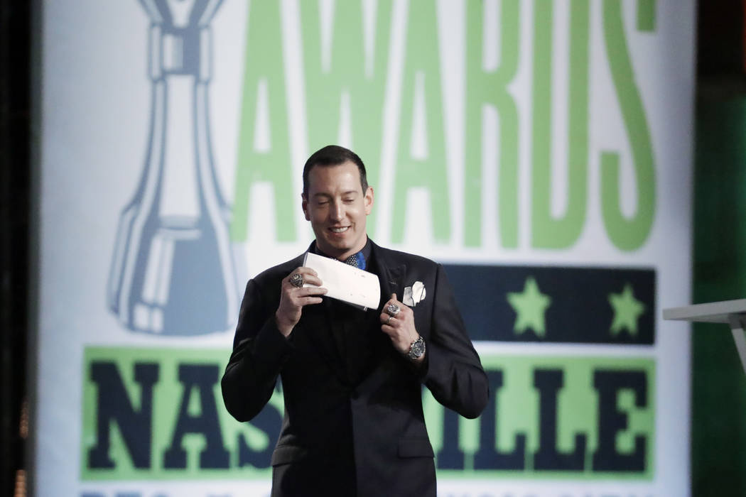 Kyle Busch pulls out his speech as he walks to the podium at the NASCAR Cup Series Awards on Th ...