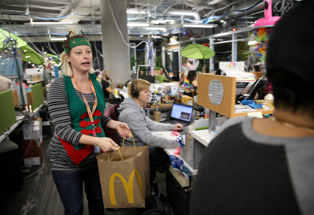 Zappos Customer Service Manager Jessica Hall hands out breakfast sandwiches at the company's he ...