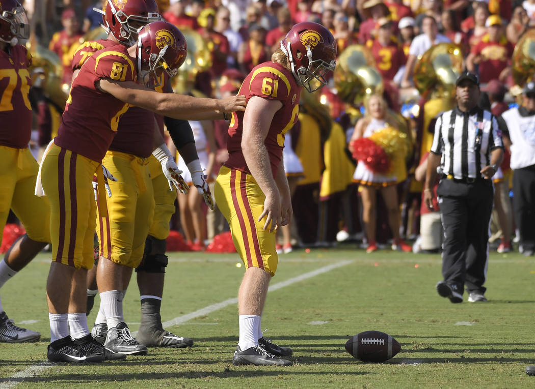 Southern California long snapper Wyatt Schmidt, left, helps long snapper Jake Olson, who is bli ...