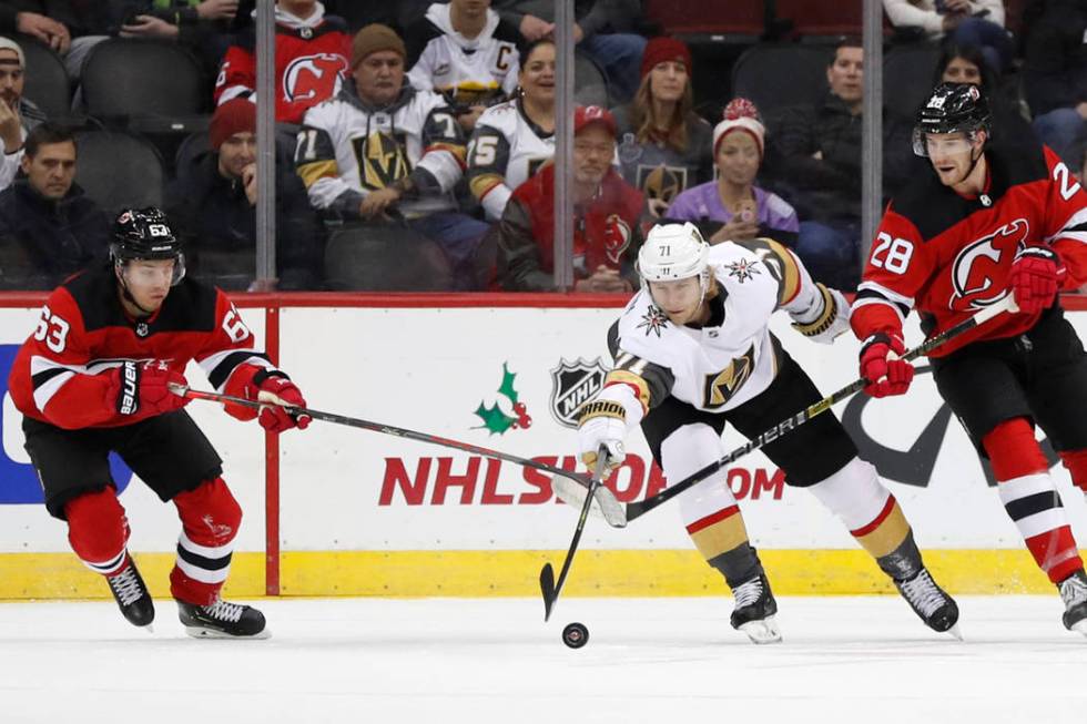 Vegas Golden Knights center William Karlsson (71) reaches for the puck as New Jersey Devils lef ...