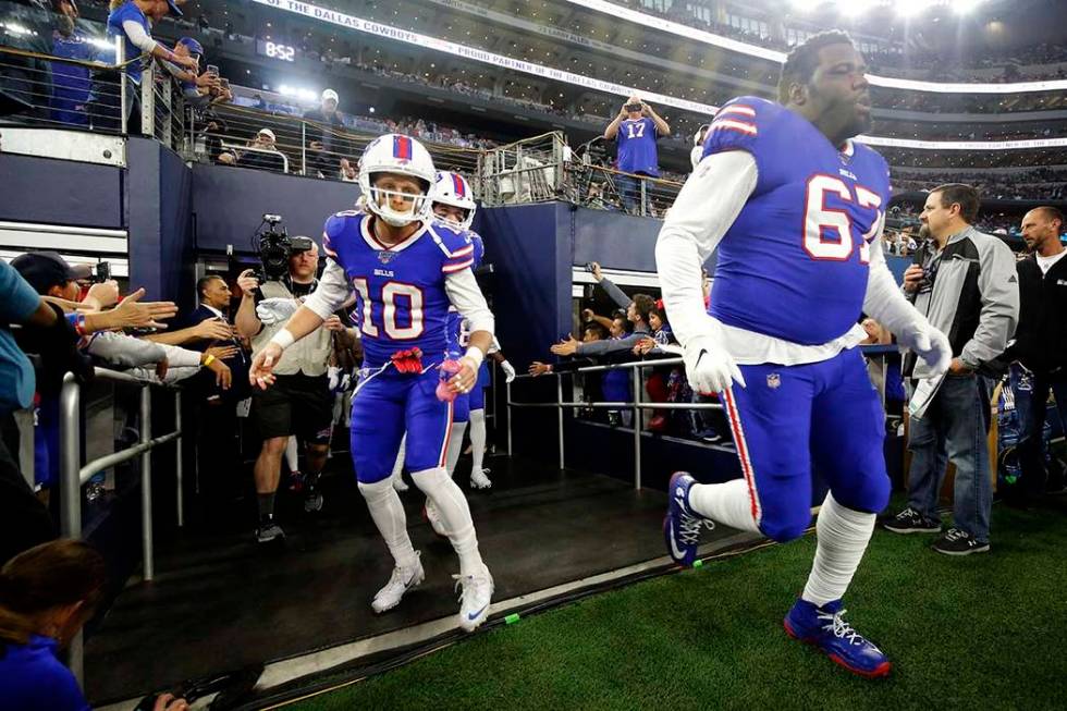 Buffalo Bills wide receiver Cole Beasley (10) and guard Quinton Spain (67) rush onto the field ...