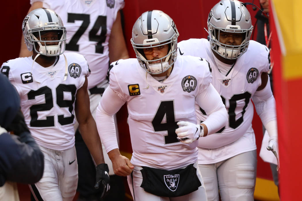 Oakland Raiders quarterback Derek Carr (4) runs out of a tunnel with free safety Lamarcus Joyne ...