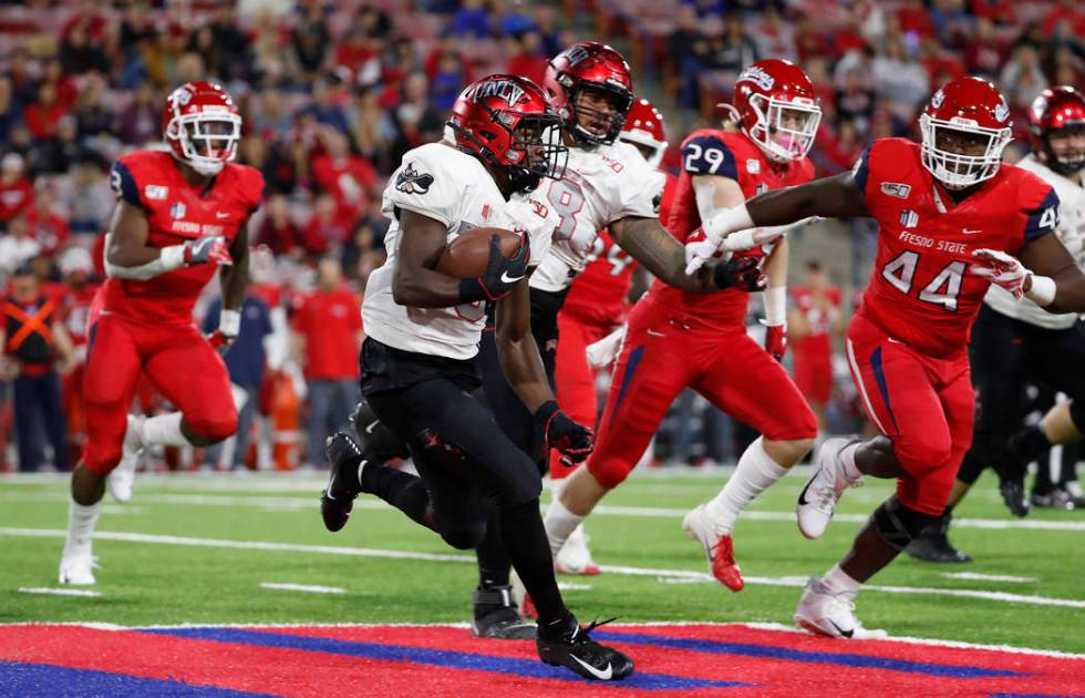 UNLV running back Charles Williams tries to get around Fresno State defensive lineman Leevel Ta ...