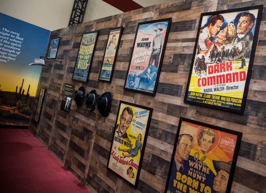 Framed movie posters staring film icon John Wayne line the walls at the "John Wayne: Spirit of ...