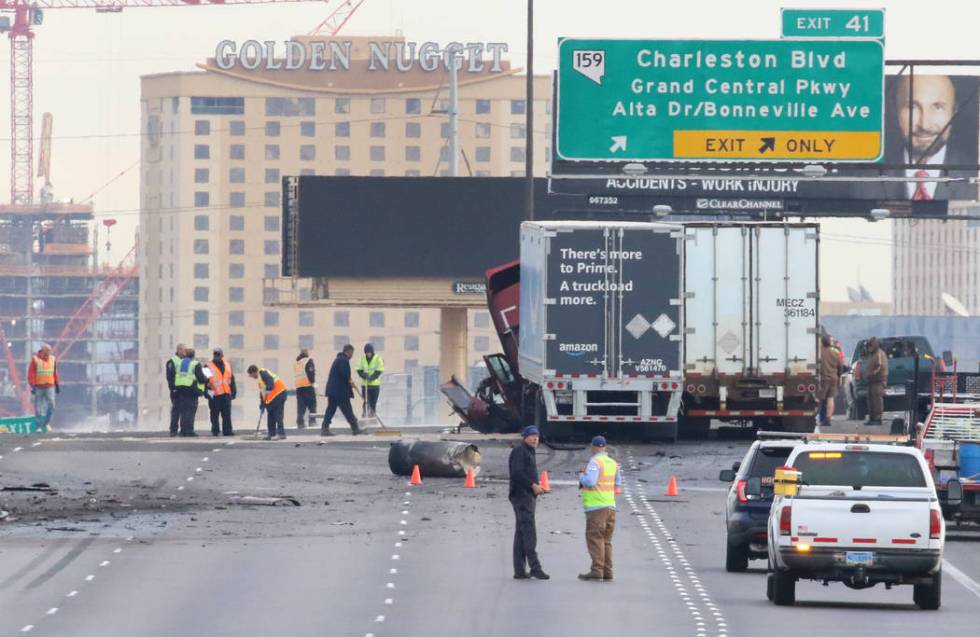 Workers clean-up debris after a fatal car crash where a wrong-way driver was killed on northbou ...