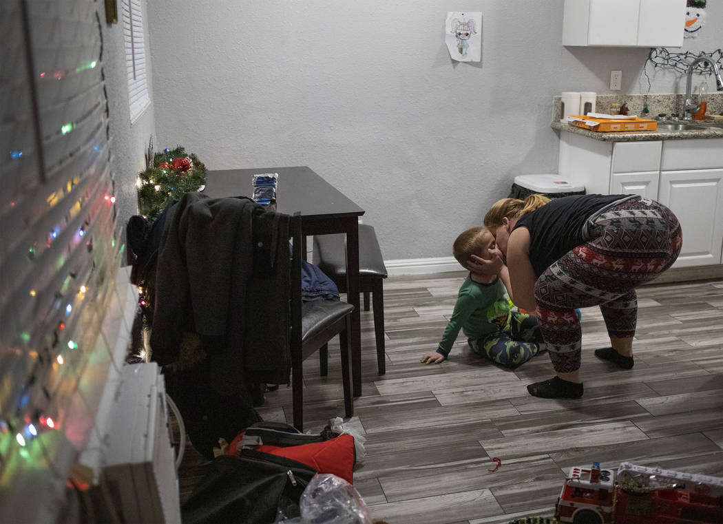 Joan Williams kisses her son, Chase Huebner, 6, in their new one-bedroom apartment on Saturday, ...