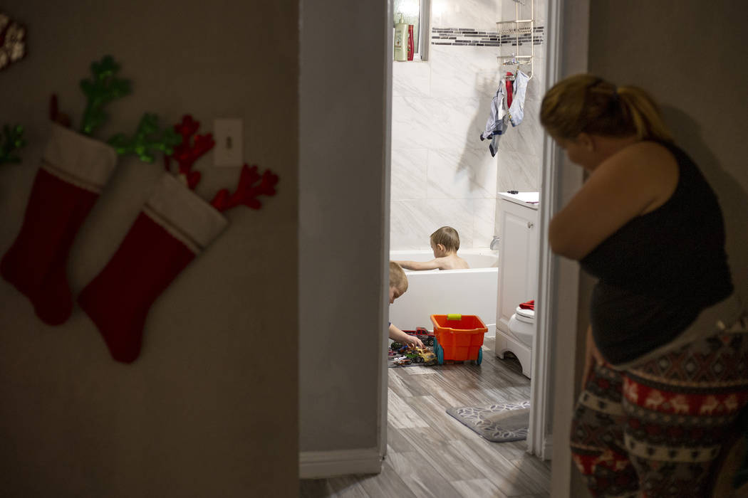 Joan Williams looks on as her sons Chase Huebner, 6, and John Huebner, 2, play in the bath duri ...
