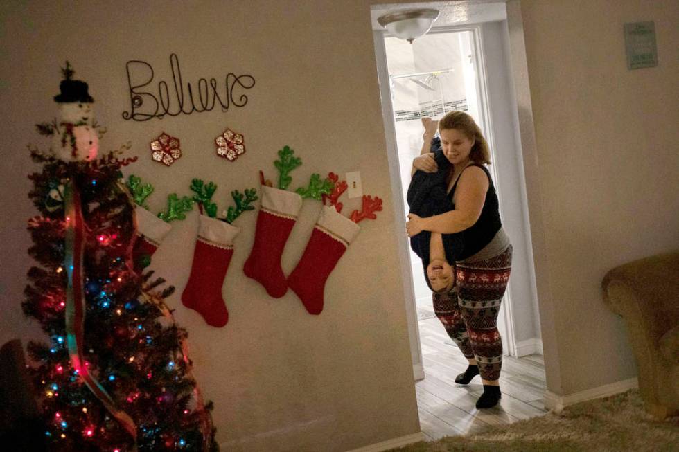 Joan Williams carries her son John Huebner, 2, from the bath during their first night at home t ...