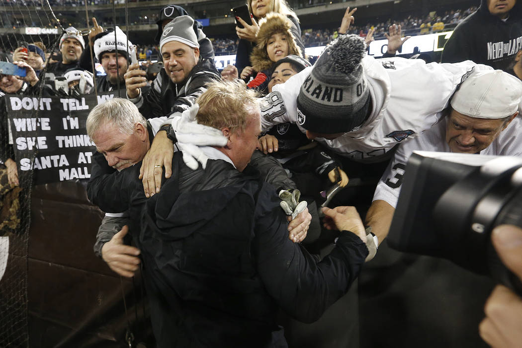 Oakland Raiders head coach Jon Gruden, bottom, hugs fans after an NFL football game against the ...