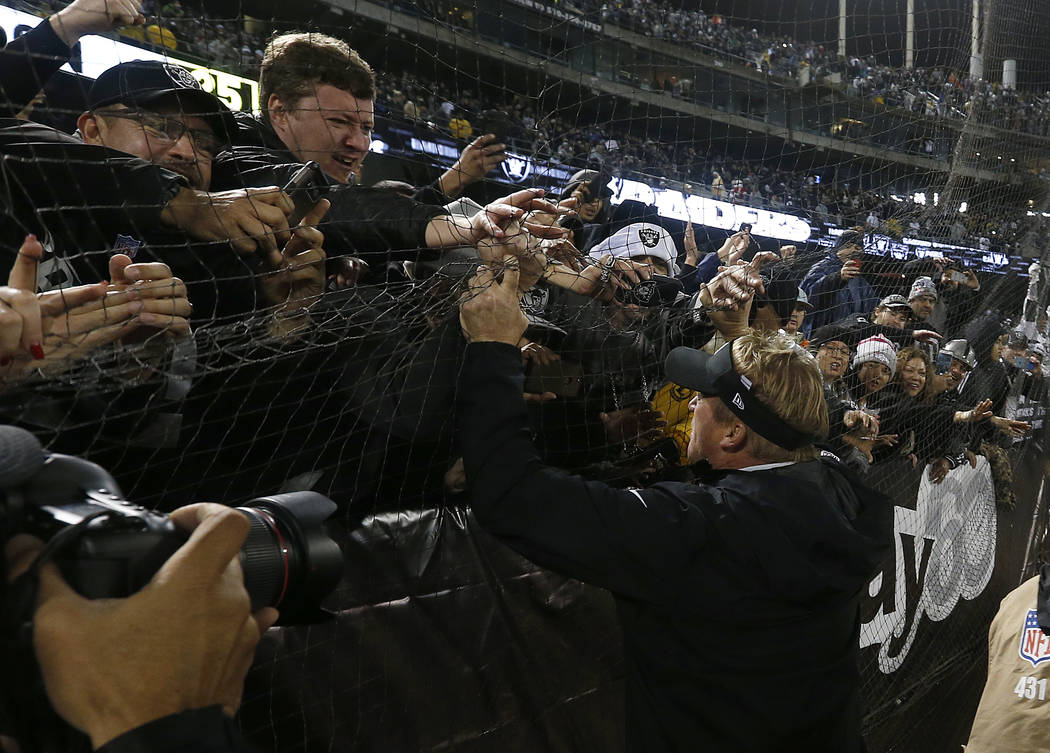 Oakland Raiders head coach Jon Gruden, bottom right, greets fans after an NFL football game aga ...