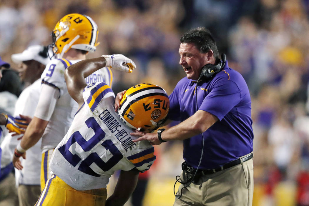 LSU coach Ed Orgeron celebrates with running back Clyde Edwards-Helaire (22) after a touchdown ...