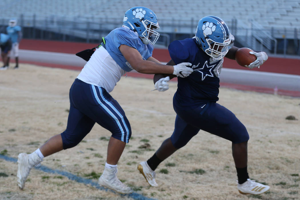 Centennial's Wesley Vailahi, left, defends a run by Keaun Jackson during a team practice at Cen ...