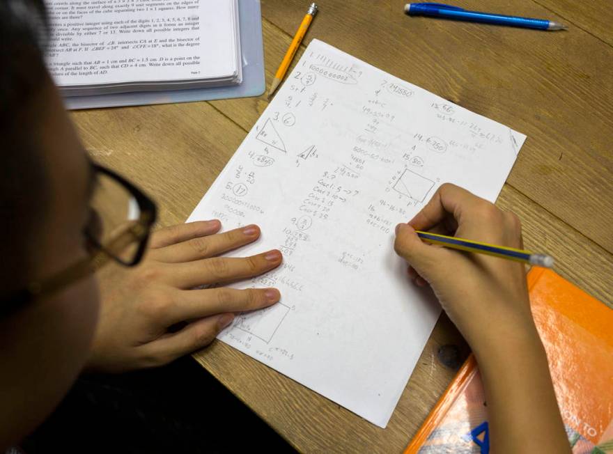UNLV student Shenlone Wu, 12, works on math proofs for fun at his parents' medical office in La ...