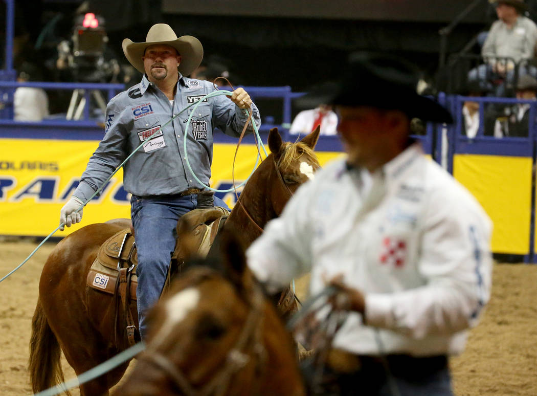Kyle Lockett of Visalia, Calif., left, after competiting in Team Roping with Erich Rogers of Ro ...