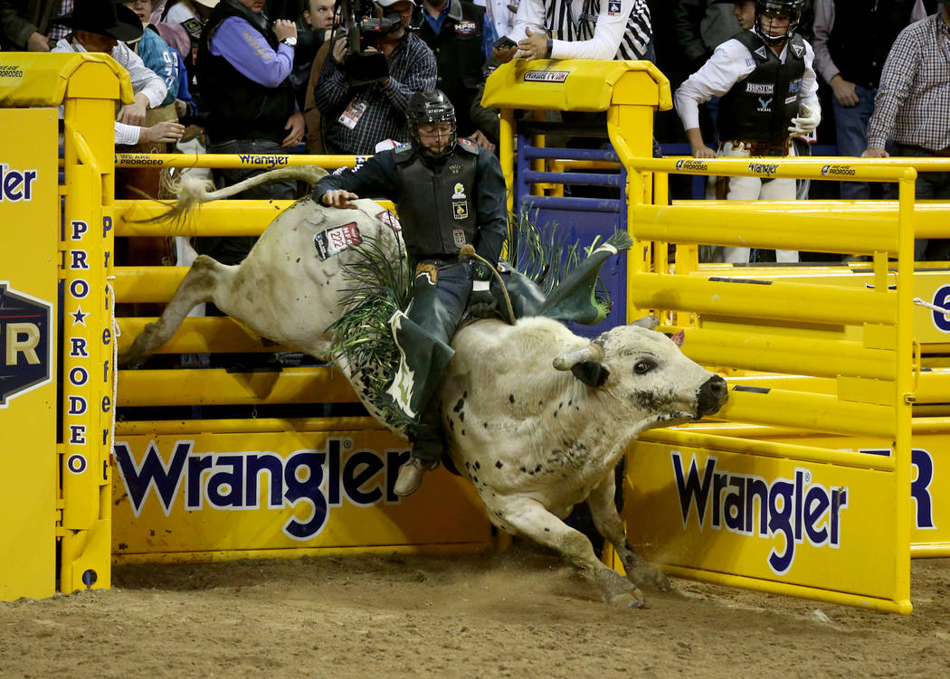 Jordan Hansen of Canada rides Hou's Bad News to a score of 89.5 in the Bull Riding competition ...