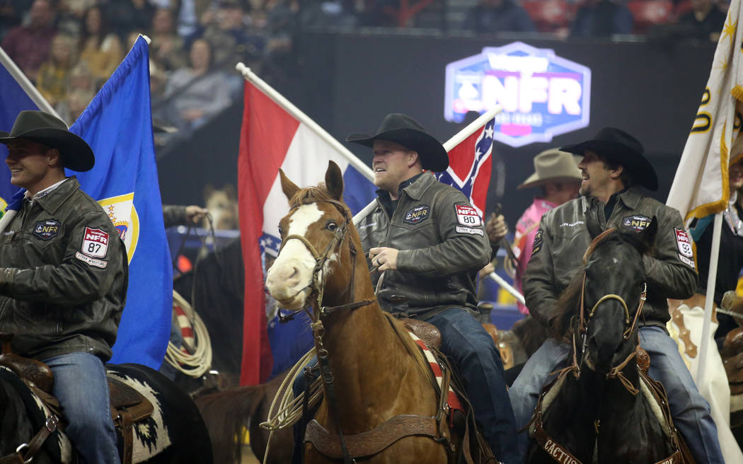 Competitors, including steer wrestlers from left, J.D. Struxness of Milan, Minn., Will Lummus o ...
