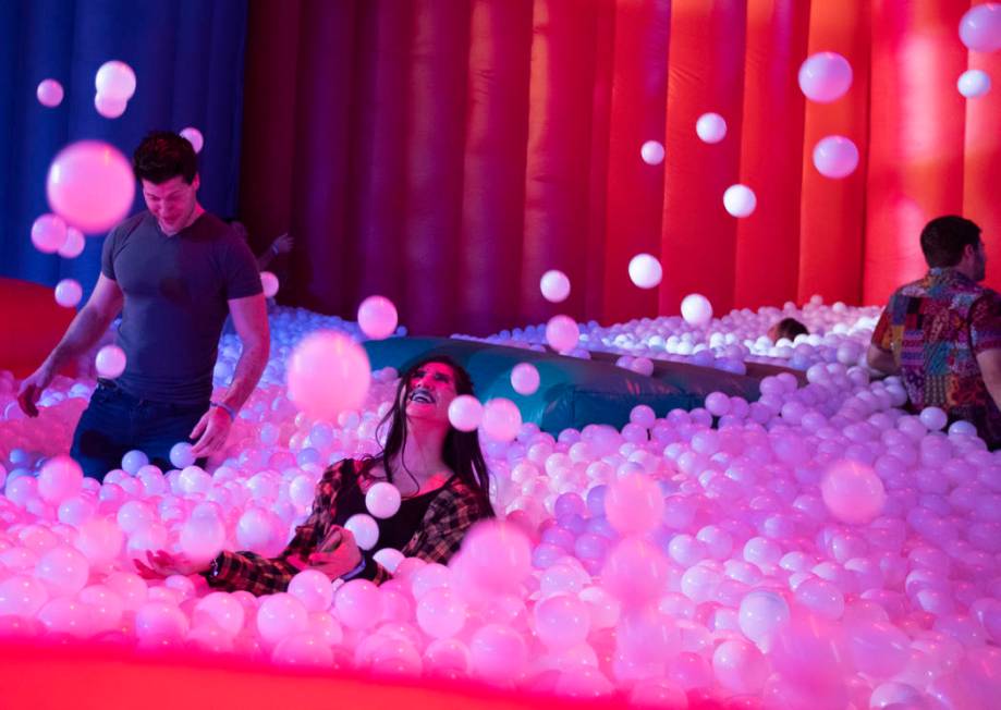 Rosa Garcia of Las Vegas, center, throws plastic balls into the air in the ball pit at Intersec ...