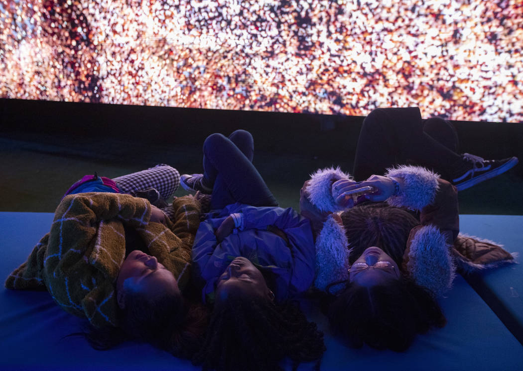 Tanisha Tavares, left, Raina Brown, center, and Jennifer Paloma, right, take a rest while watch ...