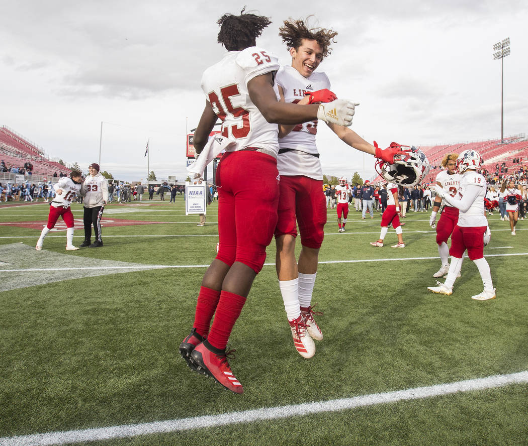 Liberty's Dominick Payne (25) celebrates with teammate Logann Britt (83) after defeating Centen ...