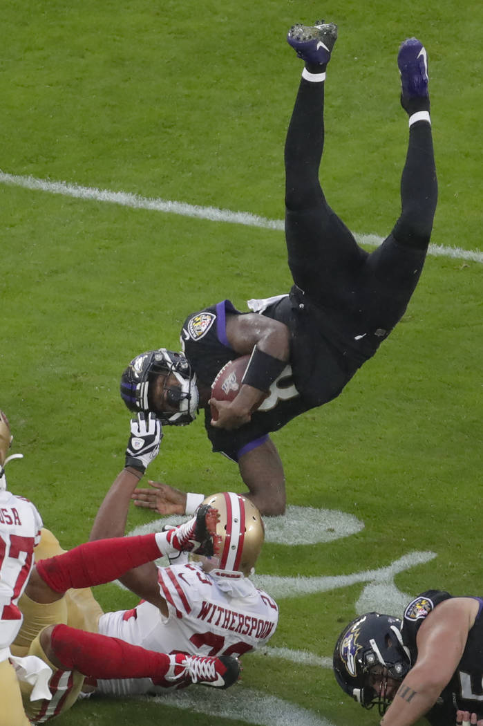 Baltimore Ravens quarterback Lamar Jackson (8) flips after being tripped by San Francisco 49ers ...