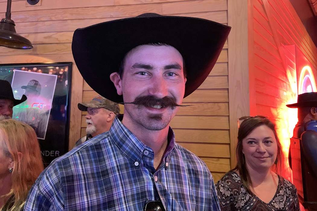 Ryder Young of Boise, Idaho, shows off his handlebar mustache while waiting among those in a lo ...
