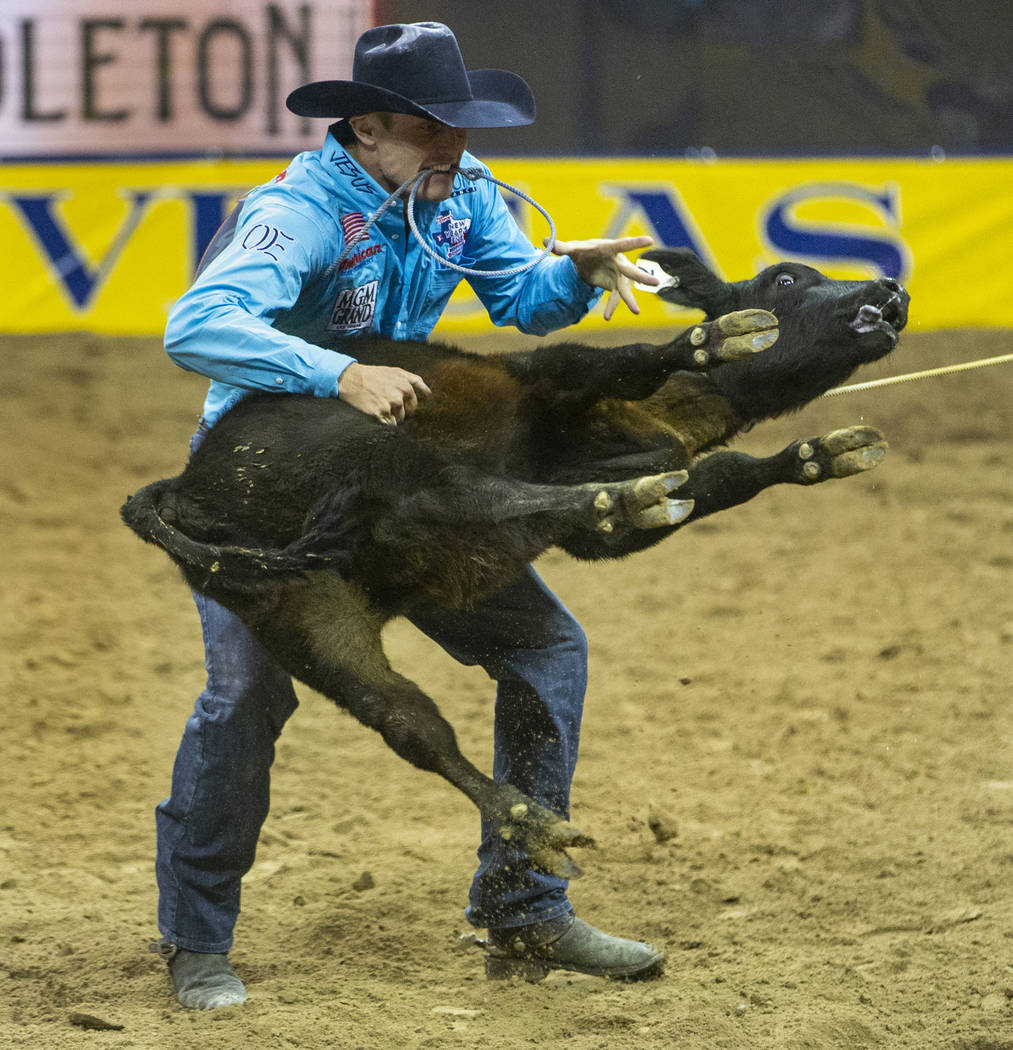 Tuf Cooper of Decatur, Texas, tosses a steer while taking first place in Tie-Down Roping with a ...