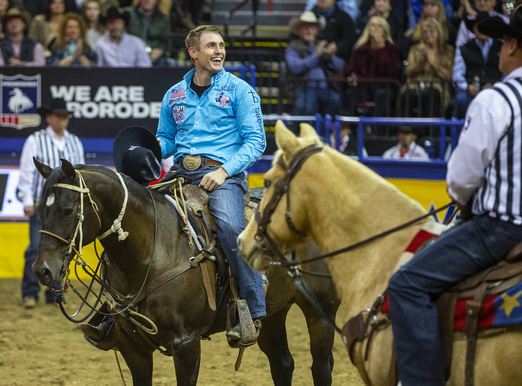 Tuf Cooper of Decatur, Texas, celebrates taking first place in Tie-Down Roping with a time of 6 ...