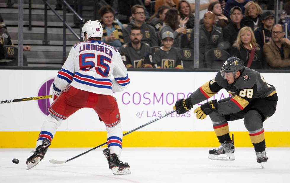 Golden Knights defenseman Nate Schmidt (88) reaches to take control of the puck as New York Ran ...