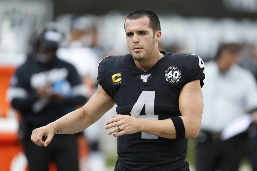 Oakland Raiders quarterback Derek Carr (4) talks on the sideline during the second half of an N ...