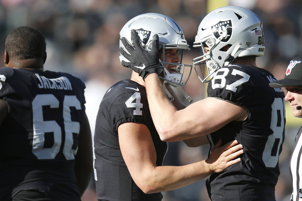 Oakland Raiders quarterback Derek Carr (4) celebrates with tight end Foster Moreau (87) after a ...