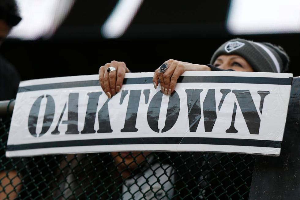 An Oakland Raiders fan holds up an Oaktown sign during the second half of an NFL football game ...