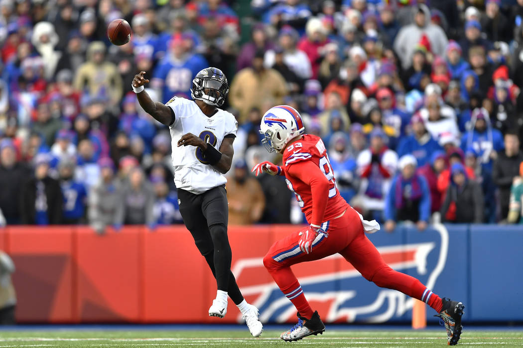 Baltimore Ravens quarterback Lamar Jackson (8) throws a pass under pressure by Buffalo Bills de ...