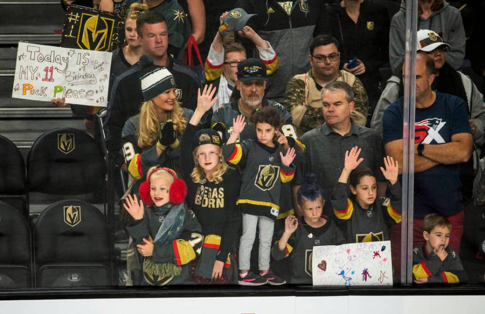 Vegas Golden Knights fans press up to the glass in hopes of getting a puck before the first per ...